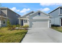 Two-story home with gray siding, attached garage, and landscaped yard at 640 Reggie Rd, Winter Haven, FL 33884