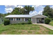Ranch-style home with carport and mature landscaping at 127 W Palmetto Ave, Deland, FL 32720