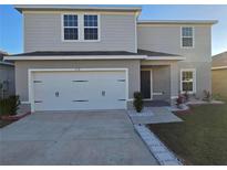 Two-story house with a two-car garage and landscaped front yard at 174 Piave St, Haines City, FL 33844