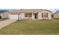 Cute ranch home with red shutters, landscaping, and a two car garage at 3405 Forsythe Ter, The Villages, FL 32162