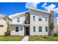 Two-story modern home with stone accents and landscaped lawn at 4209 Paragraph Dr, Kissimmee, FL 34746