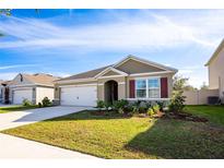 One-story home with attached garage, landscaping, and neutral color palette at 1016 Brooklet Dr, Davenport, FL 33837