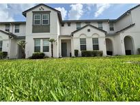 Well-maintained townhome with lush green lawn, tidy landscaping, and a gray front door at 430 Captiva Dr, Davenport, FL 33896