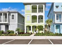 Three-story light green house with white accents and landscaping at 8049 Lost Shaker Ln, Kissimmee, FL 34747
