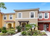 Two-story townhome with landscaping and walkway at 8558 Crystal Cove Loop, Kissimmee, FL 34747