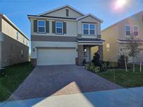 Two-story house with a large driveway and landscaping at 14521 Crestavista Ave, Clermont, FL 34714