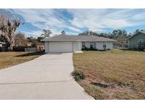 Single story home with attached garage and grassy yard at 4465 Ne 2Nd Ct, Ocala, FL 34479