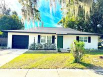 Charming ranch home with white brick exterior, black accents, and a green door at 4732 Lighthouse Cir, Orlando, FL 32808