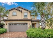 Two-story house with a neutral color scheme and a brick driveway at 8857 Rhodes St, Kissimmee, FL 34747