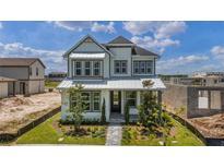 Two-story home featuring a modern facade, well-manicured landscaping, and a welcoming front porch at 9819 Gobat Aly, Orlando, FL 32827