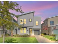 Modern two-story home with gray siding, a gray roof and a landscaped lawn at 2748 Bookmark Dr, Kissimmee, FL 34746