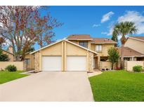Tan two-story townhouse with a two-car garage and manicured lawn at 545 Brown Pelican Dr, Daytona Beach, FL 32119