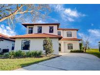 Two-story house with a tile roof, white exterior, and a two-car garage at 133 Summer Place Loop, Clermont, FL 34714