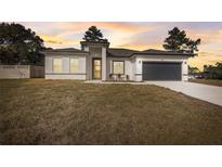 New construction home with gray garage door and landscaping at 2831 Sw 166Th Ln, Ocala, FL 34473