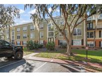 Exterior view of a condo building with landscaping and parking at 4172 Versailles Dr # 4172D, Orlando, FL 32808