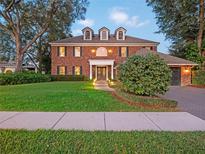 Brick two-story home with landscaping and a two-car garage at 9037 Shawn Park Pl, Orlando, FL 32819