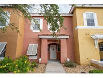 Two-story townhome with a peach-colored exterior, white shutters, and a walkway at 1065 Park Ridge Cir, Kissimmee, FL 34746