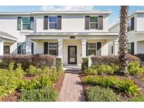 Two-story house with front porch, landscaping, and brick walkway at 11641 Fiction Ave, Orlando, FL 32832