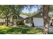 Green house with white garage door and well-manicured lawn at 2961 Cedar Glen Pl, Oviedo, FL 32765