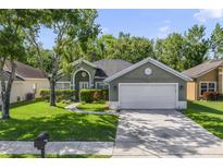 Charming single-story home with a well-maintained lawn and mature trees enhancing curb appeal at 2961 Cedar Glen Pl, Oviedo, FL 32765