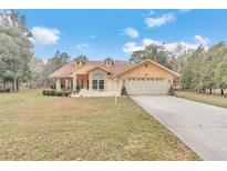 Charming one story home featuring a two-car garage and an inviting brick entryway at 8520 Sw 209Th Ct, Dunnellon, FL 34431