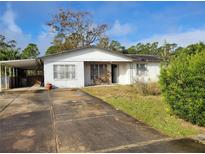 White brick ranch house with a carport and mature landscaping at 1070 N Libby Ct, Daytona Beach, FL 32117