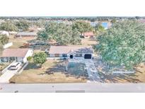 Aerial view of a single-story house with a large yard and lake nearby at 37 Hickory Track Way, Ocala, FL 34472