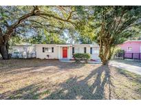 Updated one-story home with red front door and mature landscaping at 5216 Montague Pl, Orlando, FL 32808