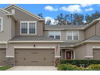 Two-story townhome with attached garage and landscaped front yard at 8426 Chamberlain Pl, Oviedo, FL 32765