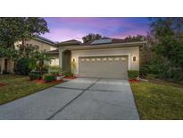 House exterior featuring a two-car garage and manicured lawn at 10952 Arbor View Blvd, Orlando, FL 32825