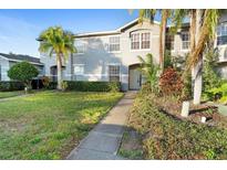 Two-story townhome with landscaped lawn and walkway at 13312 Summerton Dr, Orlando, FL 32824