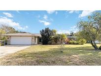 House exterior with stone facade, attached garage, and spacious lawn at 1429 Royal Palm Dr, Edgewater, FL 32132
