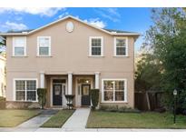 Two-story tan house with two front doors, a walkway, and a small lawn at 328 E Kaley St, Orlando, FL 32806