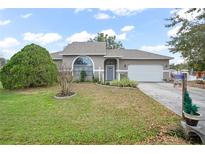 Charming one-story house with gray siding, a gray door, and a well-manicured lawn at 430 Magpie Ct, Kissimmee, FL 34759