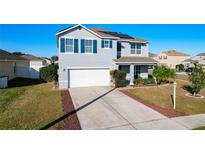 Two story house with driveway, landscaping and solar panels at 6163 Forest Ridge Way, Winter Haven, FL 33881