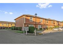 Orange two-story townhome with parking and landscaping at 7403 Glen Oaks Way # 82, Winter Park, FL 32792