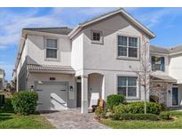 Two-story house with gray exterior, two-car garage, and landscaped yard at 1564 Flange Dr, Davenport, FL 33896