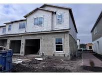 Two-story house under construction with two-car garage, block exterior, and landscaping at 5106 Rain Shadow Dr, Saint Cloud, FL 34772