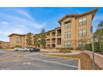 Tan colored building exterior with parking and landscaping at 914 Charo Pkwy # 113, Davenport, FL 33897