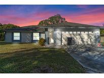 Single-story home with attached garage and landscaped yard at 9405 Holbrook Dr, Orlando, FL 32817
