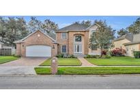 Charming two-story brick home features manicured lawn and attached two-car garage at 9425 Belmont Ter, Oviedo, FL 32765