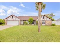 Single-story home with a stone facade and a palm tree in the front yard at 110 Dianne Dr, Ormond Beach, FL 32176