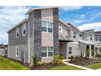 Modern two-story home with gray exterior and stone accents at 1176 Challenge Dr, Davenport, FL 33896