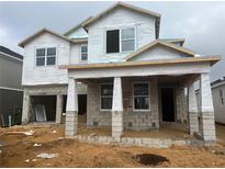 Two-story house under construction, featuring a covered porch and block exterior walls at 16881 Muskgrass Dr, Winter Garden, FL 34787