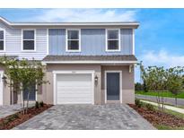 Charming two-story townhome featuring a private garage and stylish gray-toned brick driveway at 3326 Thicket St, Tavares, FL 32778