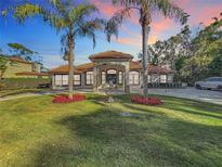 Stunning two-story home with a tile roof, lush landscaping, and a circular driveway at 3415 S Mellonville Ave, Sanford, FL 32773