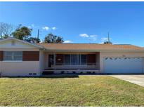 Ranch-style home with brick facade, attached garage, and well-maintained lawn at 3430 N Westmoreland Dr, Orlando, FL 32804