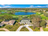 Stunning aerial view of a home on a golf course with a lake and a circular driveway at 8513 Bay Hill Blvd, Orlando, FL 32819