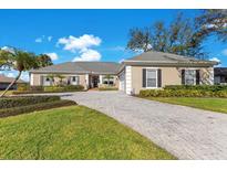 Charming home with a manicured lawn, beautiful landscaping and a spacious brick driveway at 8513 Bay Hill Blvd, Orlando, FL 32819