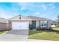 One-story home with white garage door, teal front door, and landscaped lawn at 2128 Silver Brook Way, Davenport, FL 33837